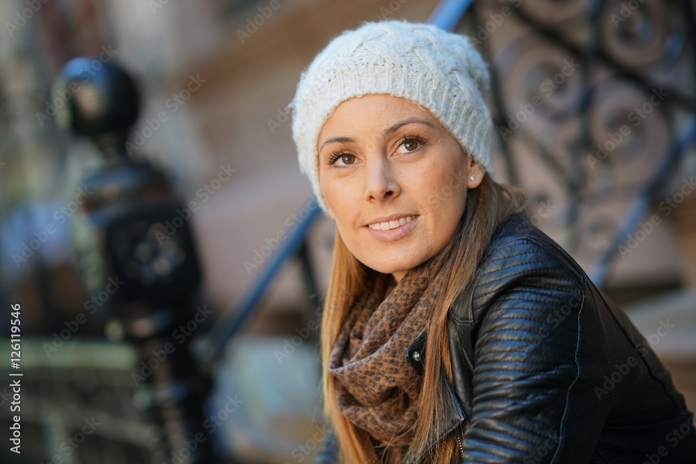 Trendy girl with winter hat sitting on house front porch Trendy girl with winter hat sitting on house front porch