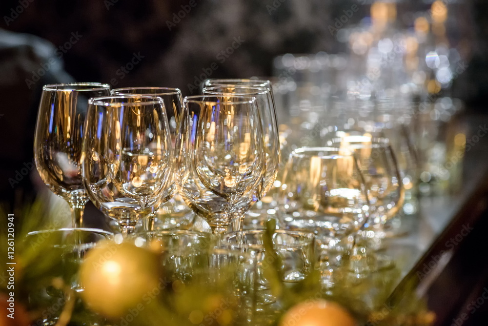 Glasses, forks, knives, napkins and decorative flower on a table served for dinner in cozy restaurant. Glasses, forks, knives, napkins and decorative flower on a table served for dinner in cozy restaurant.