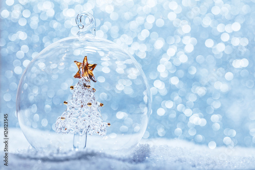 Christmas glass ball with crystal tree inside in snow photo