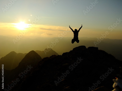 Woman jumping Hands up on the Top of the Nebelhorn Mountains in Germany Alps