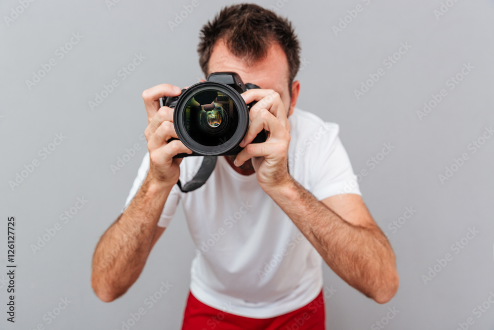 Portrait of a male photographer with camera taking photo Portrait of a male photographer with camera taking photo