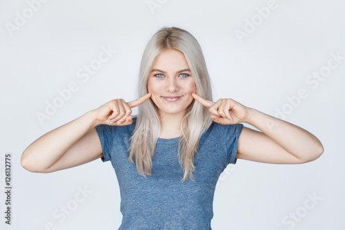 Foto Young woman with fingers pointing to her dimples
