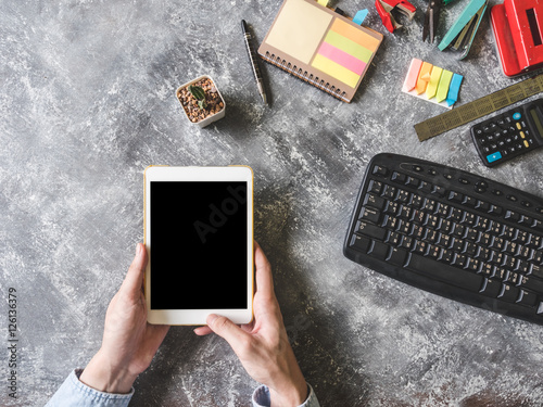 Top view of Male hands using Tablet with Office supplies on the desk. photo