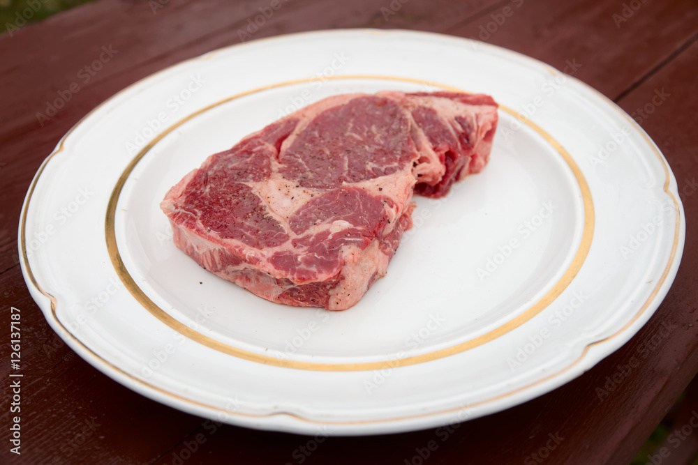 Rib eye steak on a rustic plate