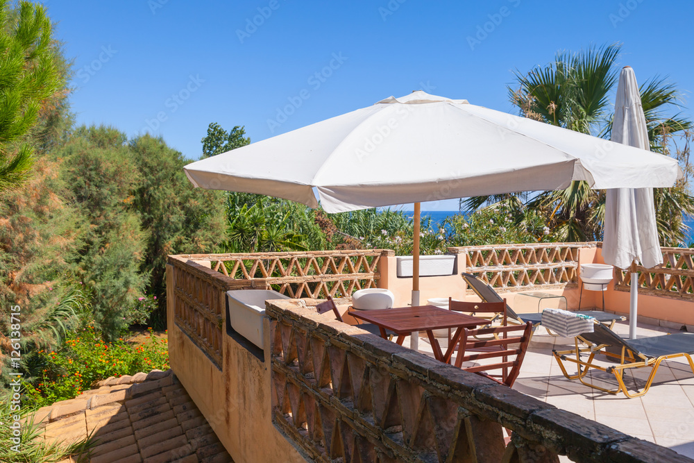 Seaside balcony with white umbrella. Zakynthos