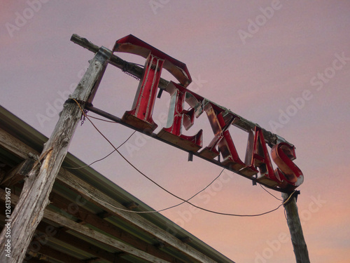 Texas neon sign against evening sky with rustic wood