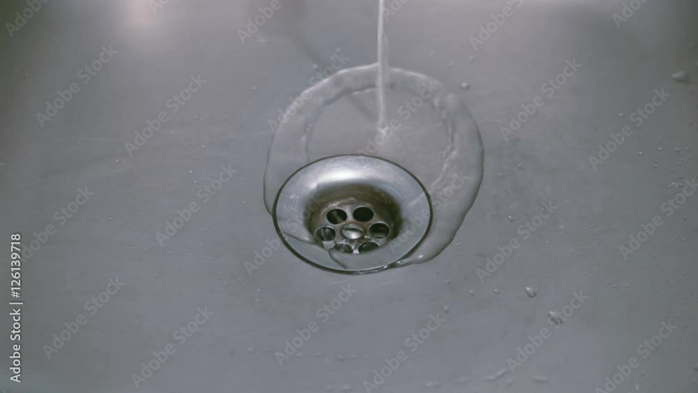 jet of water pouring in metal sink strainer jet of water pouring in metal sink strainer