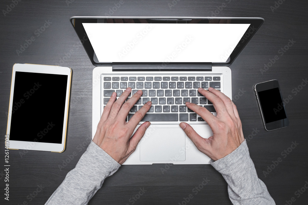 Fototapeta premium Top view of Male hands working on Laptop on the desk.