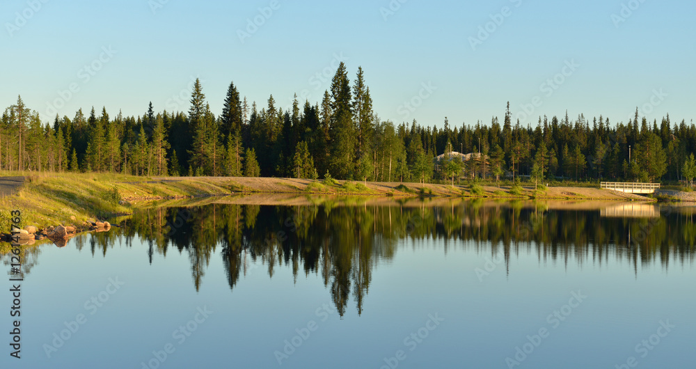 Reflection. Coastline of northern lake. Lapland, Finland