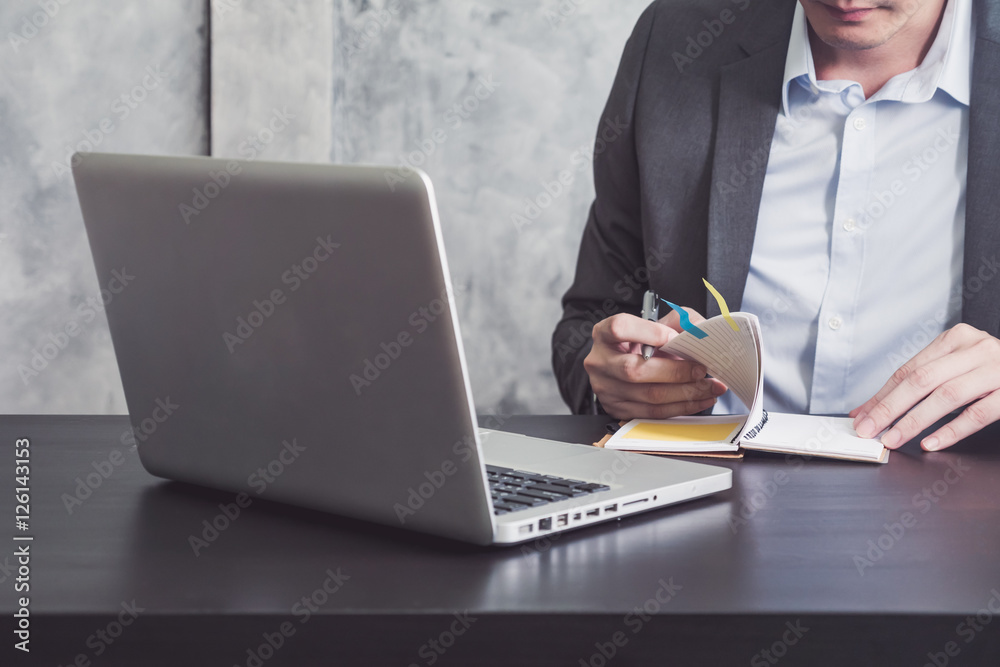 Close up of Businessman reading notebook on the desk. Close up of Businessman reading notebook on the desk.
