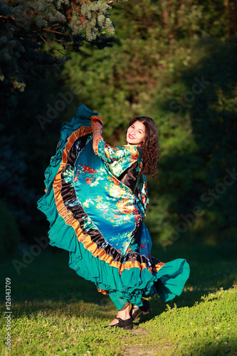 Beautiful gypsy girl in a traditional dance in the woods