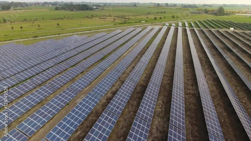 Aerial of a solar panel park, low shot flying across. photo