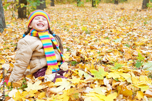 girl child sit in autumn forest  beautiful landscape in fall season with yellow leaves