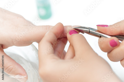 Manicurist uses professional manicure tool.