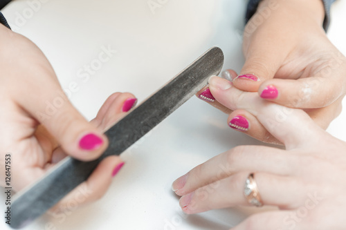 woman in a beauty salon receiving a manicure