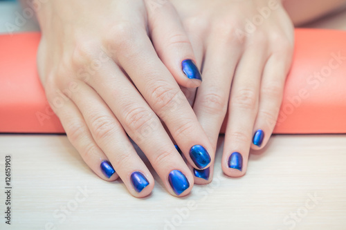 female hands with  blue nail Polish  close-up