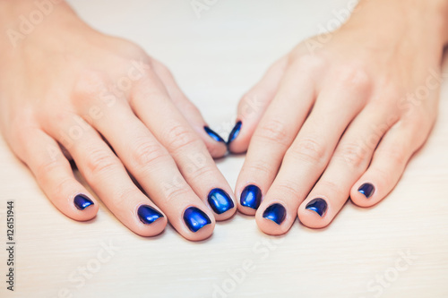 female hands with  blue nail Polish, close-up