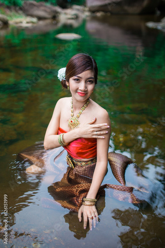 Fototapeta Naklejka Na Ścianę i Meble -  Beautiful girl with Thai dressing was playing water in the river.