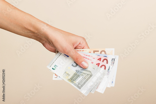 Woman's hand with money on a light background