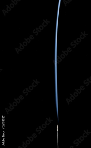 Incense stick with smoke on black background