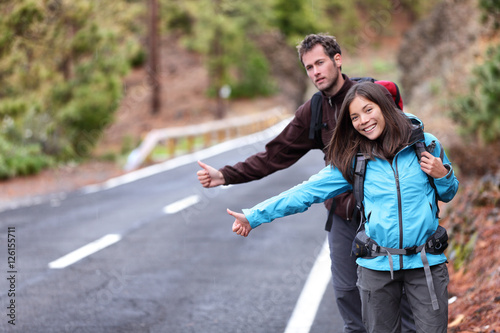 Travel hikers couple hitchhiking on road trip