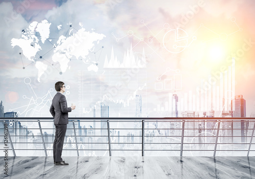 Businessman with coffee studying graphs in the sky © ImageFlow