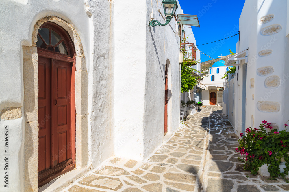 Street in Parikia town with church in distance on Paros island, Greece