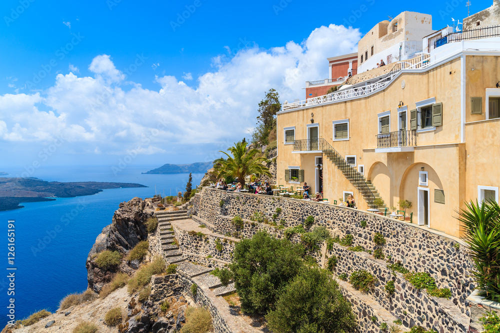 Restaurant terrace with tourists dining and enjoying beautiful sea view, Santorini island, Greece