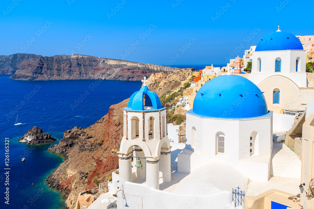 Fototapeta premium Słynne niebieskie kopuły białych kościołów w miejscowości Oia na wyspie Santorini, Grecja