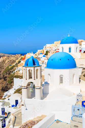Famous blue domes of white churches in Oia village on Santorini island, Greece