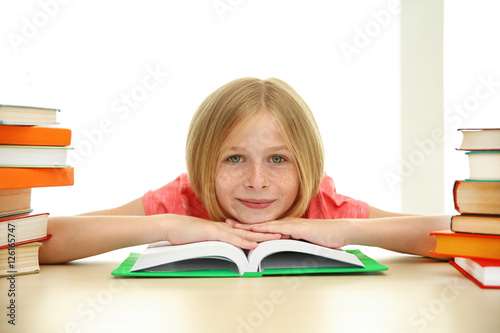 Smiling girl with many book...