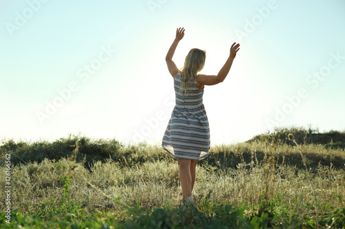 Silhouette of young woman on blue sky background