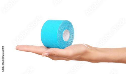 Female hand holding special physio tape roll on white background photo