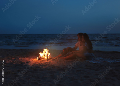 Lovely couple near fireplace on beach photo