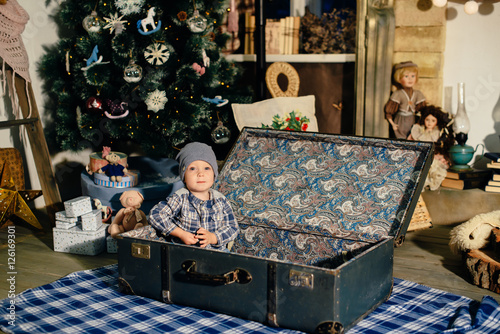 little boy in a suitcase in the Christmas decor, the child in the new year © ShevarevAlex