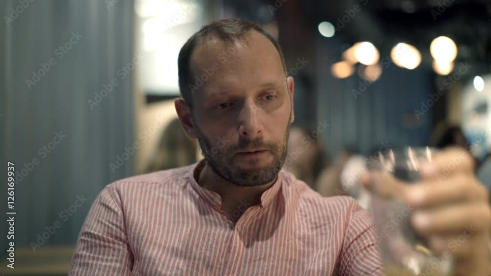 Sad, unhappy man drinking beer sitting in cafe at night
Sad, unhappy man drinking beer sitting in cafe at night