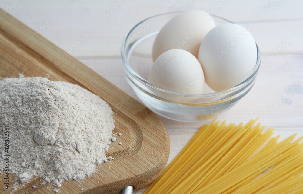 chicken eggs, spaghetti, flour on a white background chicken eggs, spaghetti, flour on a white background