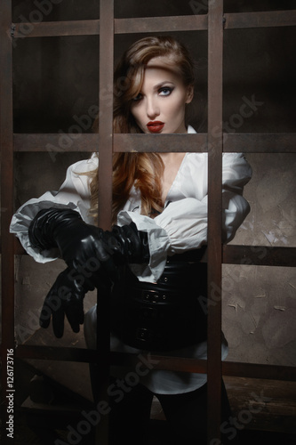 Beautiful woman in pirate style as prisoner