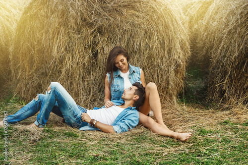 Vászonkép Young lovely couple is relaxing among the haystacks
