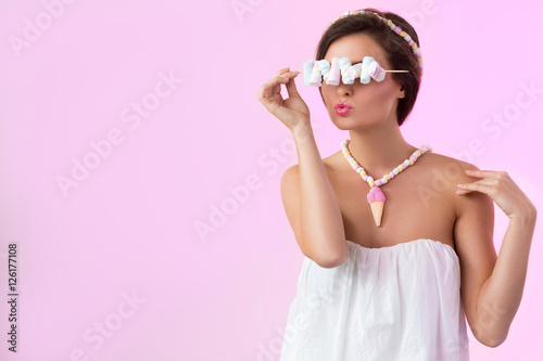 Happy beautiful woman with marshmallows on the skewer photo
