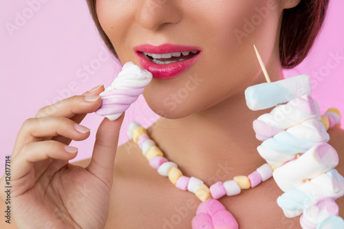 Happy beautiful woman with marshmallows on the skewer