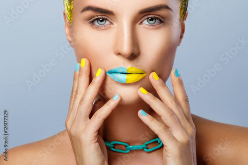 Beautiful woman with yellow hair and colorful nails and lips