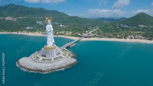 Flying towards a tall white Buddha statue on the tropical island Hainan, China photo