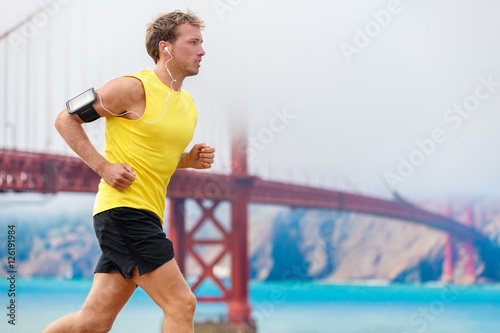 Photography Athlete running man - male runner in San Francisco listening to music on smartphone