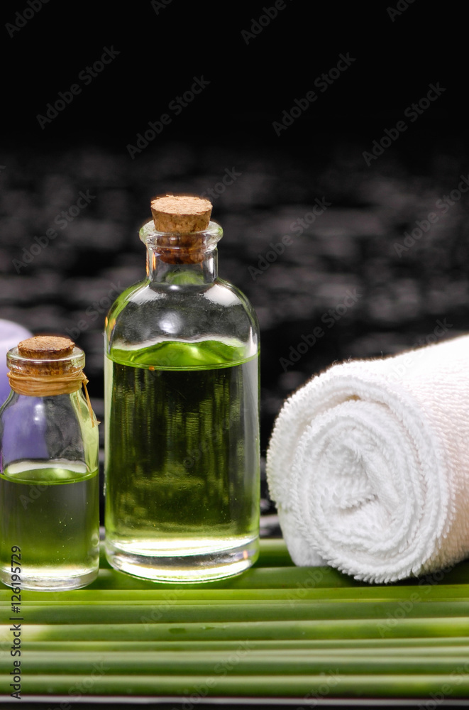 tranquil spa scene- towel with black stones with candle ,green plant