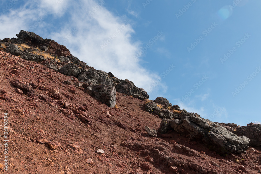 A steep, challenging mountain side covered with volcanic rocks