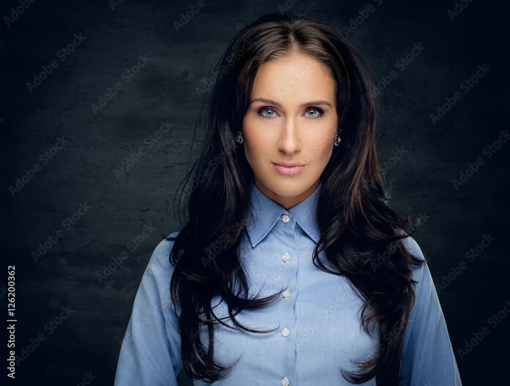 Studio portrait of brunette female in a blue shirt. Studio portrait of brunette female in a blue shirt.