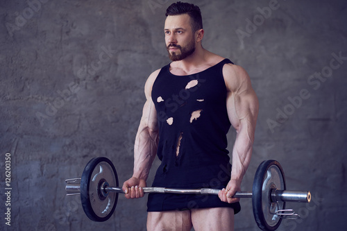 Bearded bodybuilder working out with barbell.