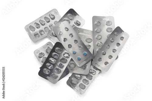 Blue pills package on pile of empty pill packages isolated on white background