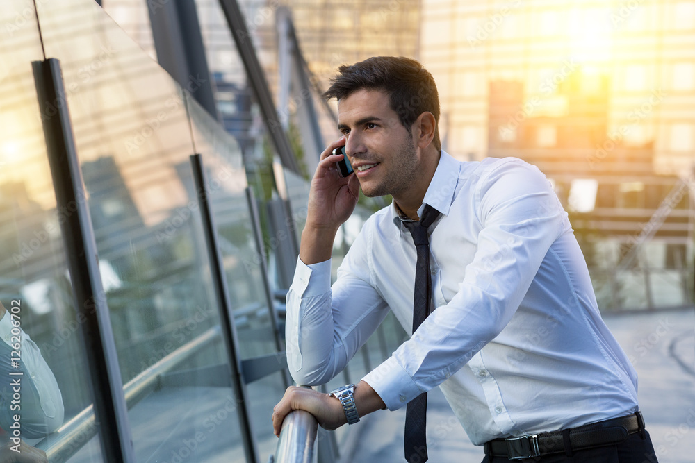 Businessman talking on phone in financial district Businessman talking on phone in financial district